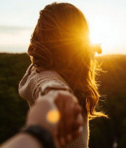 pareja en un campo agarrados de la mano felices despues de un amarre de amor efectivo