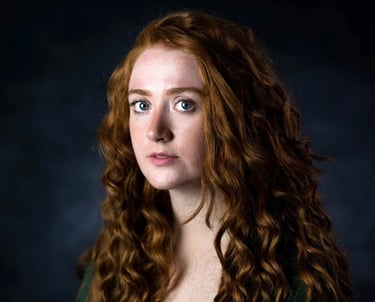 a woman with long red hair and blue eyes