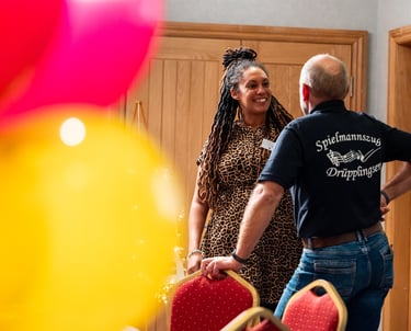 Two people chatting at a community event - a candid moment of connection in a vibrant setting