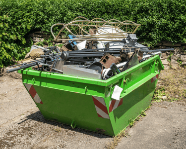 a green dumpster full of scrap metals
