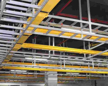 a large aluminum cable ladder with yellow cable tray and red pipes
