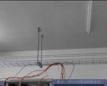a line of wire mesh cable tray are hanging from the ceiling
