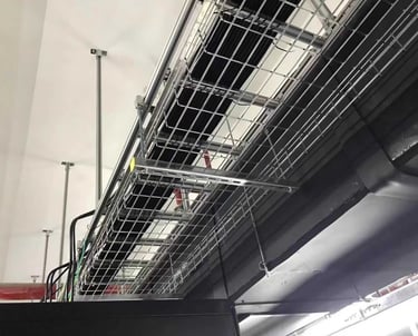 a metal wire mesh cable tray with bundles cables hanging in the ceiling