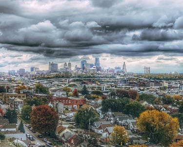 Downtown Kansas City, Missouri landscape photo taken during the fall with vibrant trees and deep, cloudy skies.