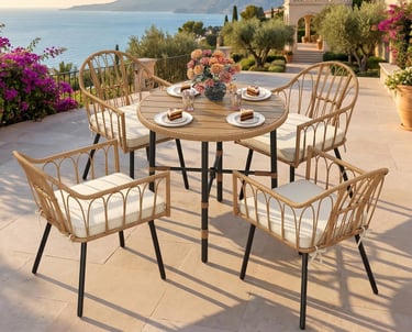 Elegant wicker patio dining set with a round table and four chairs on a terrace overlooking the ocean.