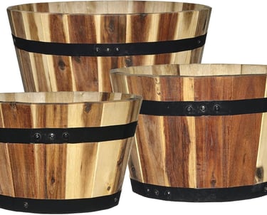 Set of three rustic wooden barrel planters with black metal bands for garden decor.