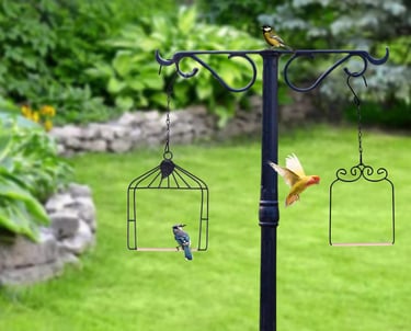 A black metal bird feeder pole in a green garden with a blue jay and yellow birds.
