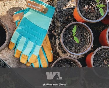 HydraHyde leather gardening gloves next to small potted seedlings in a sunny garden setting.