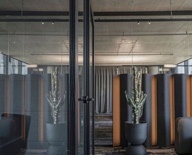 Biuro interjeras Kaune, Vitlaima, darbo vietos, betoninės lubos, užuolaidos, akustinė sienelė