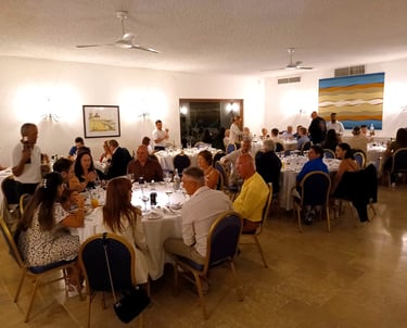 Guests enjoying a formal group dinner and banquet at an elegantly set restaurant event venue.
