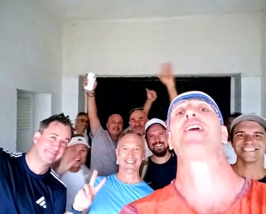 A diverse group of happy male friends taking a cheerful group selfie indoors.