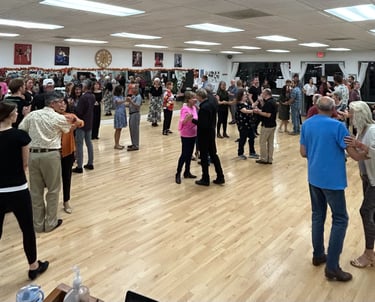 smiling dancers attend a social event at mccann dance learning a ballroom dance.