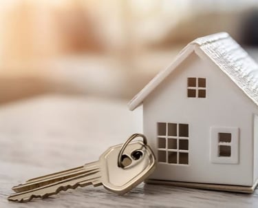 a table with house keys next to a model house