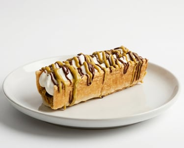 Le Menifeuille du Chef Menisy : feuilleté croustillant garni de crème, nappage chocolat et pistache, création signature.
