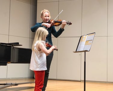 Houston violin teacher performing at a recital with her violin student