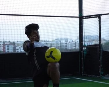 a man holding a soccer ball in a cage