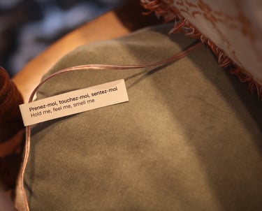 Cushion reading “hold me, touch me, smell me” vibrates with sounds of cooking and shared meals.