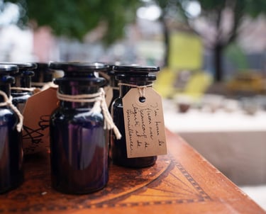 Apothocarie bottles with twine and handwritten notes on top of a wooden table in a park