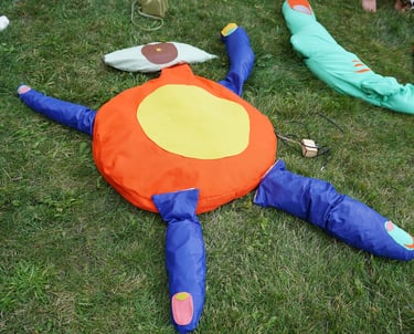 Soft sculptures of body parts arranged into a human like figure with an eye for the head.