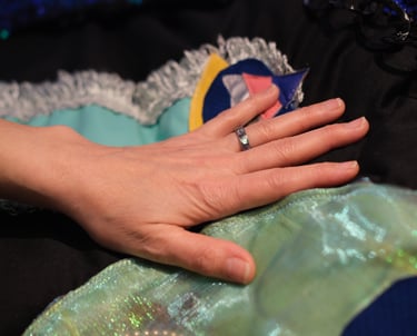 A hand touches sparkly fabrics on a velvet cushion vibrating with underwater sounds