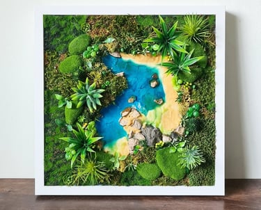 A framed piece of art using resin, artificial moss, preserved moss sand and stones to create a lush