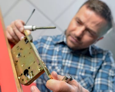 Professional locksmith installing a brass door lock cylinder mechanism for home security repair.
