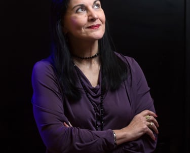 Ritratto della giornalista Clara Mennella, specializzata in food & wine, con sguardo verso l’alto su sfondo scuro.