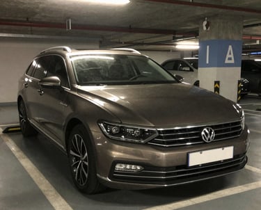 A sleek black sports car parked under soft lighting, highlighting its polished curves.