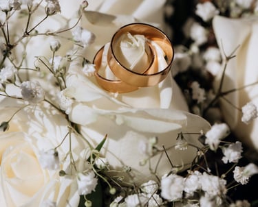 a couple of wedding rings on a bouquet of flowers
