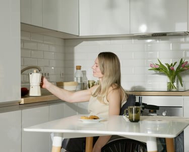 a woman sitting at a table with a bottle of wine