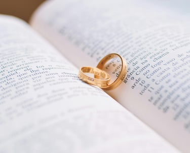 a wedding ring with two wedding rings on top of a book
