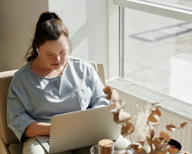 a woman sitting in a chair with a laptop computer
