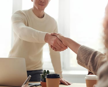 a man and woman shaking hands in a meeting
