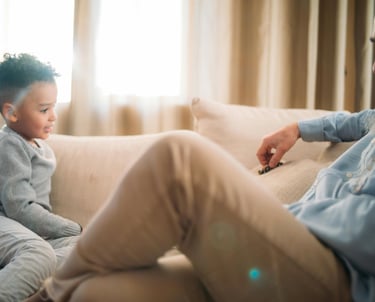 a man sitting on a couch with a child