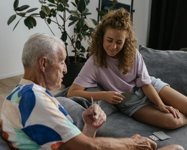 a woman sitting on a couch with a man holding a remote control