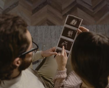 a man and woman sitting on a couch looking at photos of themselves