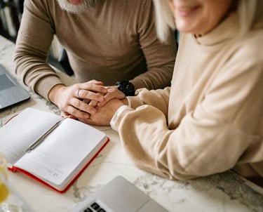 a man and woman holding hands over a notebook