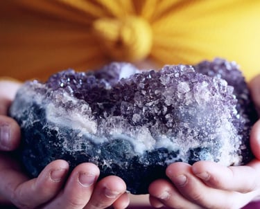 a purple Amethyst cluster crystal held in hands