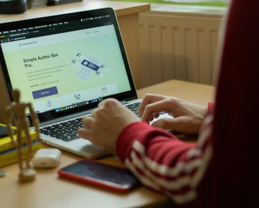 Person typing on laptop, web design page open