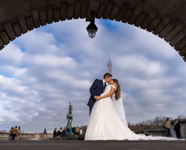 "Pareja heterosexual casada besándose bajo la Torre Eiffel en París, celebrando su amor y unión."