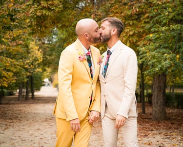 "Pareja gay casada en Madrid, besándose en un parque, celebrando su boda y el amor."