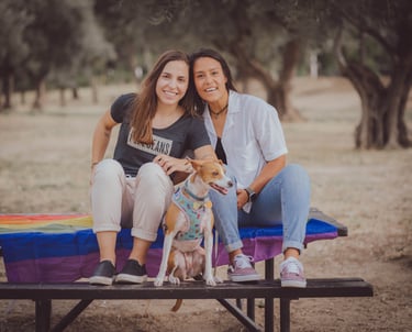 "Pareja lesbiana en el Gay Pride de Madrid, con su perro, celebrando el amor y la diversidad LGBTQ+."