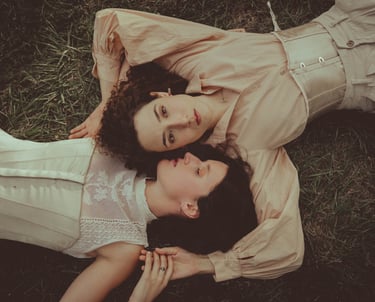 "Pareja lesbiana vista desde arriba, abrazándose en el suelo, celebrando el amor en una boda gay."