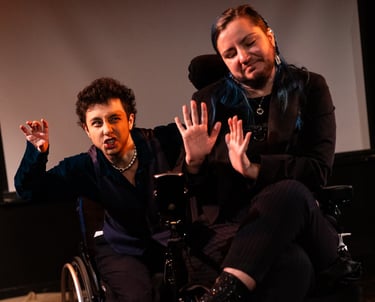Two people signing BSL, one in a manual and one in an electric wheelchair