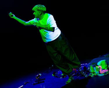 A white person bathed in green light, reaching up towards... something