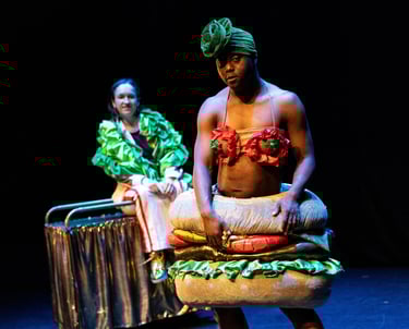 A black person dressed as a burger, with a white person dressed as lettuce behind them