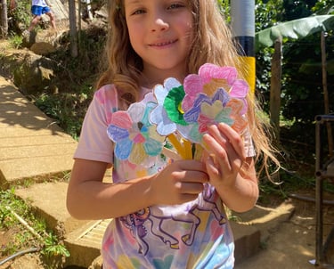 una niña sosteniendo una flor de papel