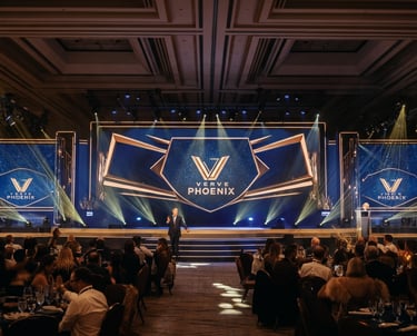 Verve Phoenix-managed corporate event with a vibrant stage setup, glowing screens, and audience engagement.