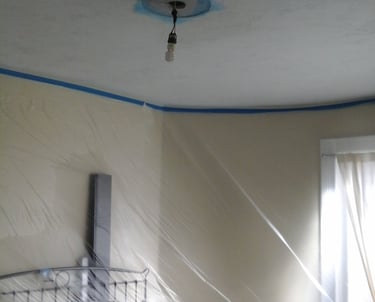 room with plastic masking on walls