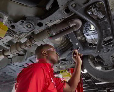 A Big O Tire employee inspecting a car